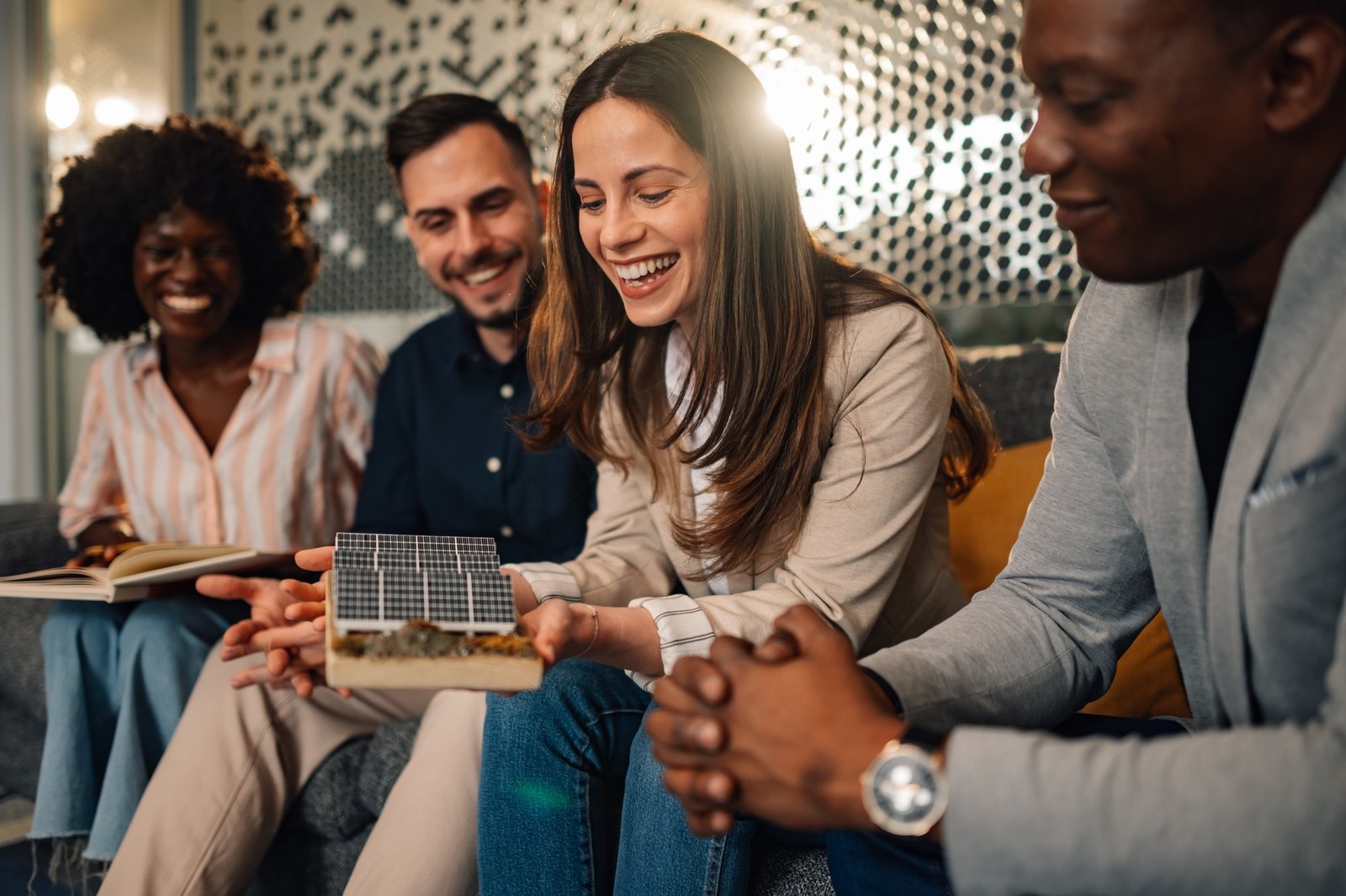 Interracial investors with solar panels discussing renewable resources